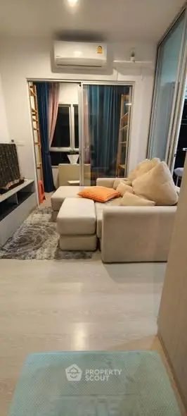 Cozy living room with modern beige sofa and stylish decor in a contemporary apartment.