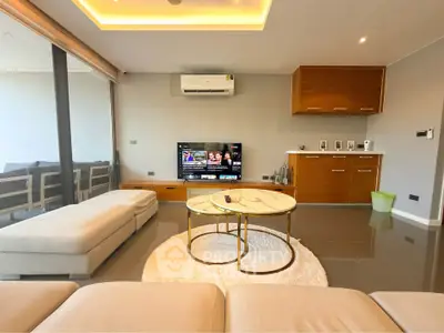 Modern living room with sleek furniture and large glass doors opening to a balcony.