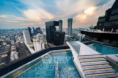 Stunning rooftop pool with panoramic city skyline views at sunset.