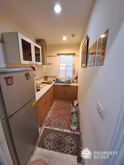 Cozy kitchen space with ample cabinetry, modern appliances, and a charming window letting in natural light, ideal for culinary enthusiasts.