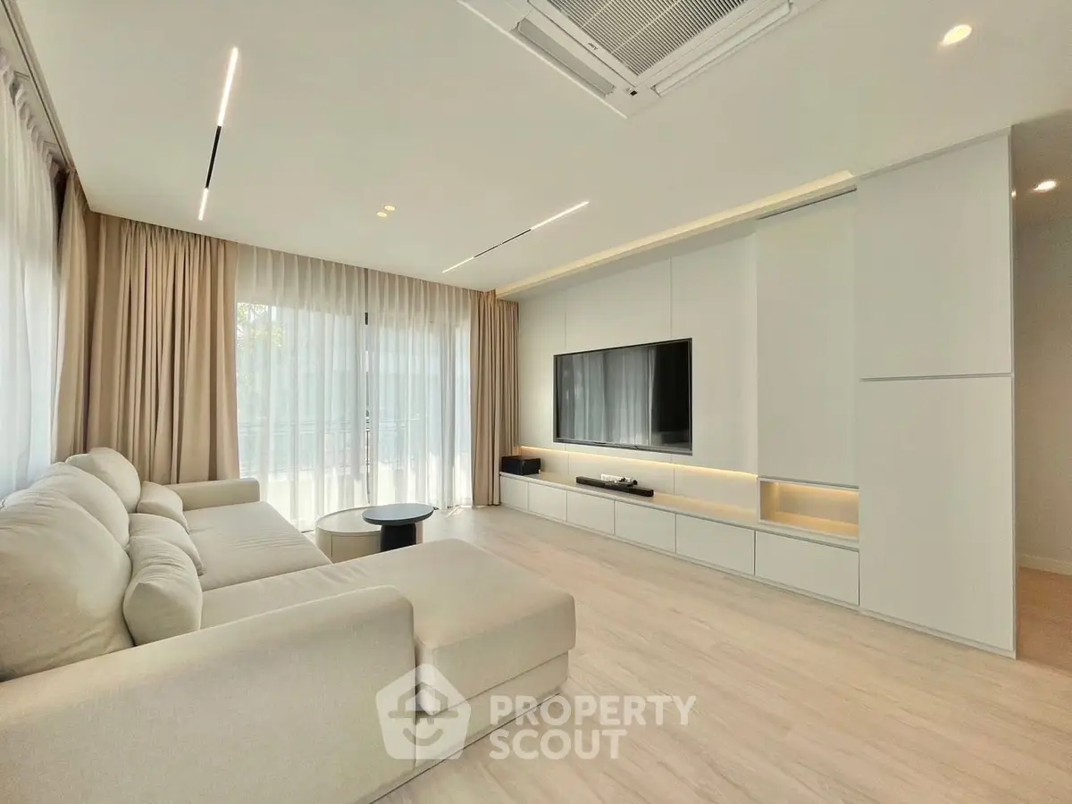 Modern living room with sleek design, large windows, and cozy sectional sofa.