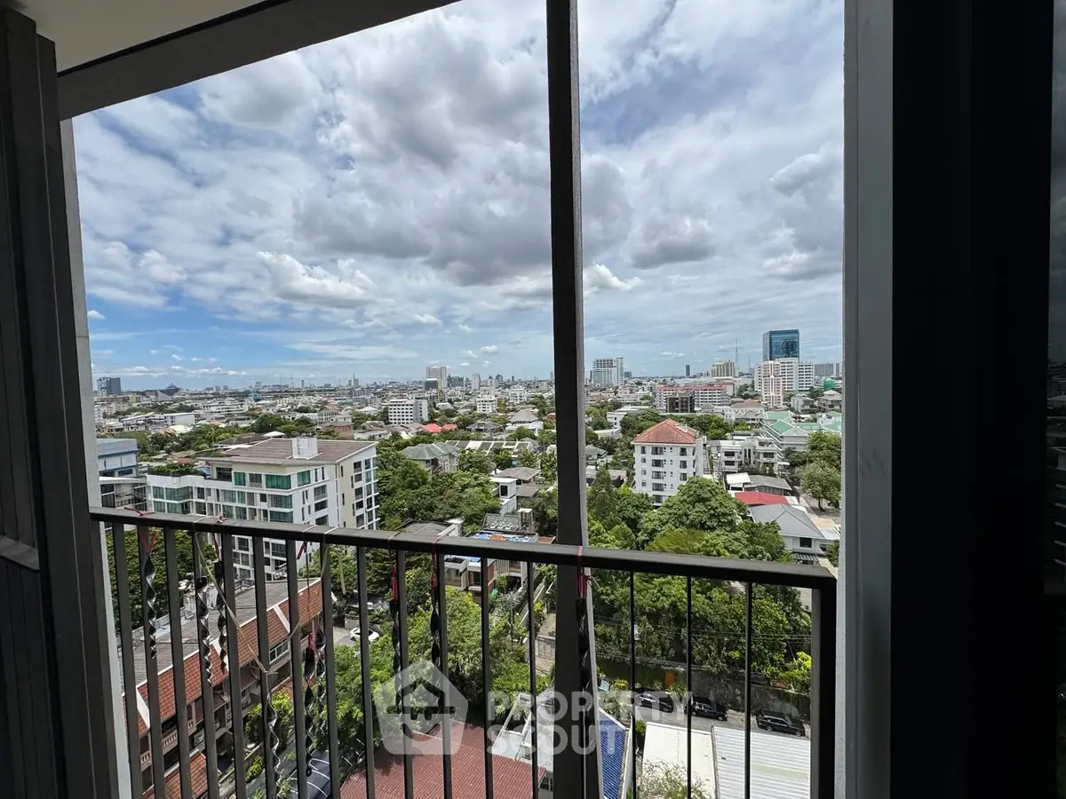 Stunning cityscape view from a high-rise balcony with lush greenery and skyline.