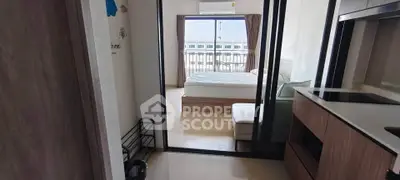 Modern apartment interior with sliding glass doors leading to a cozy bedroom and balcony view.