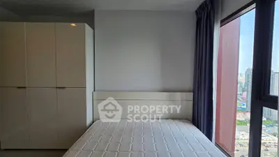 Modern bedroom with large window offering city view, featuring a sleek wardrobe and comfortable bed.