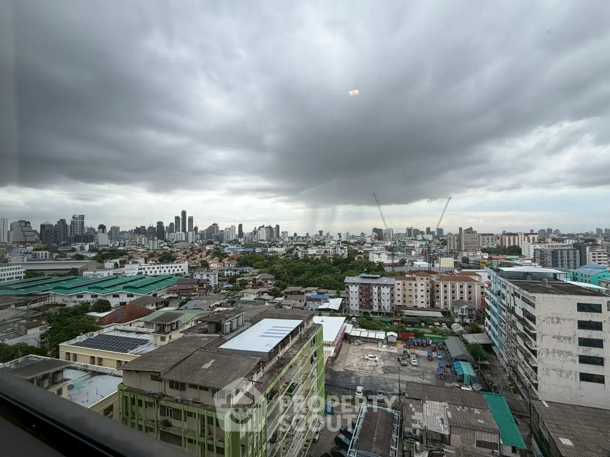 Stunning cityscape view from high-rise building with dramatic cloudy sky.