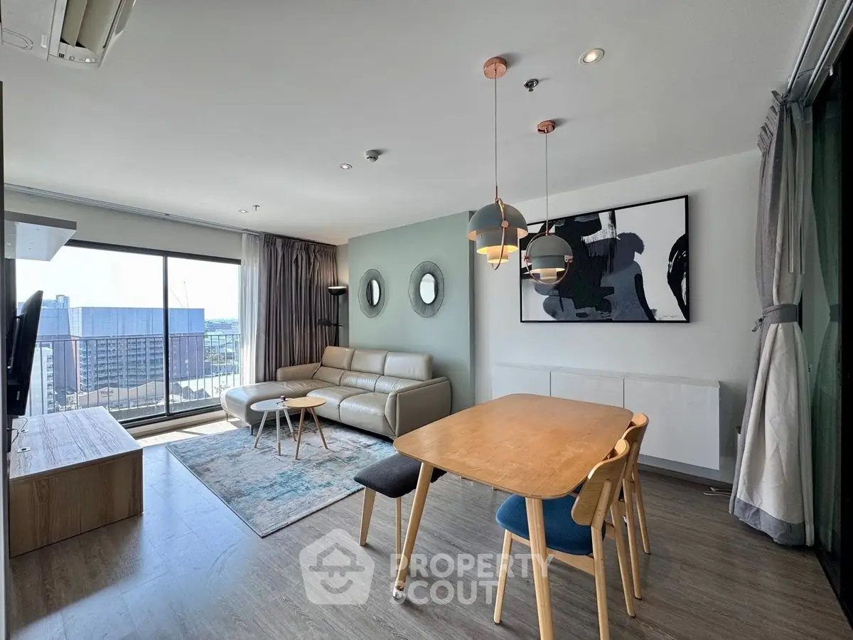 Modern living room with stylish decor and city view from large windows.