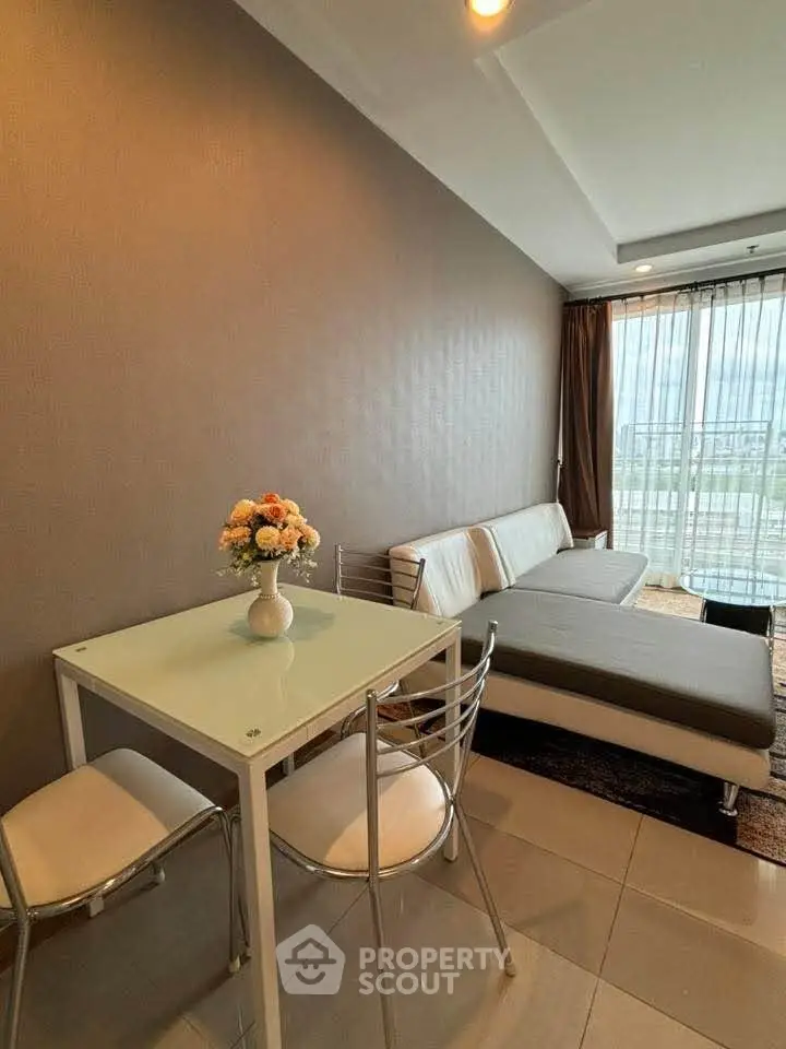 Modern living room with sleek furniture and large window offering city view.