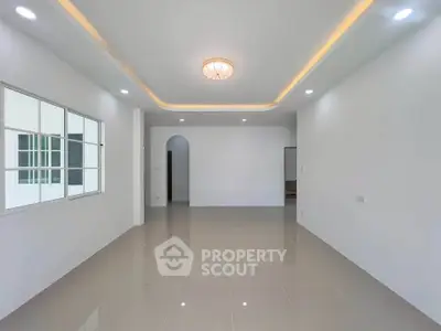 Spacious modern living room with elegant ceiling lights and glossy tiled floor.