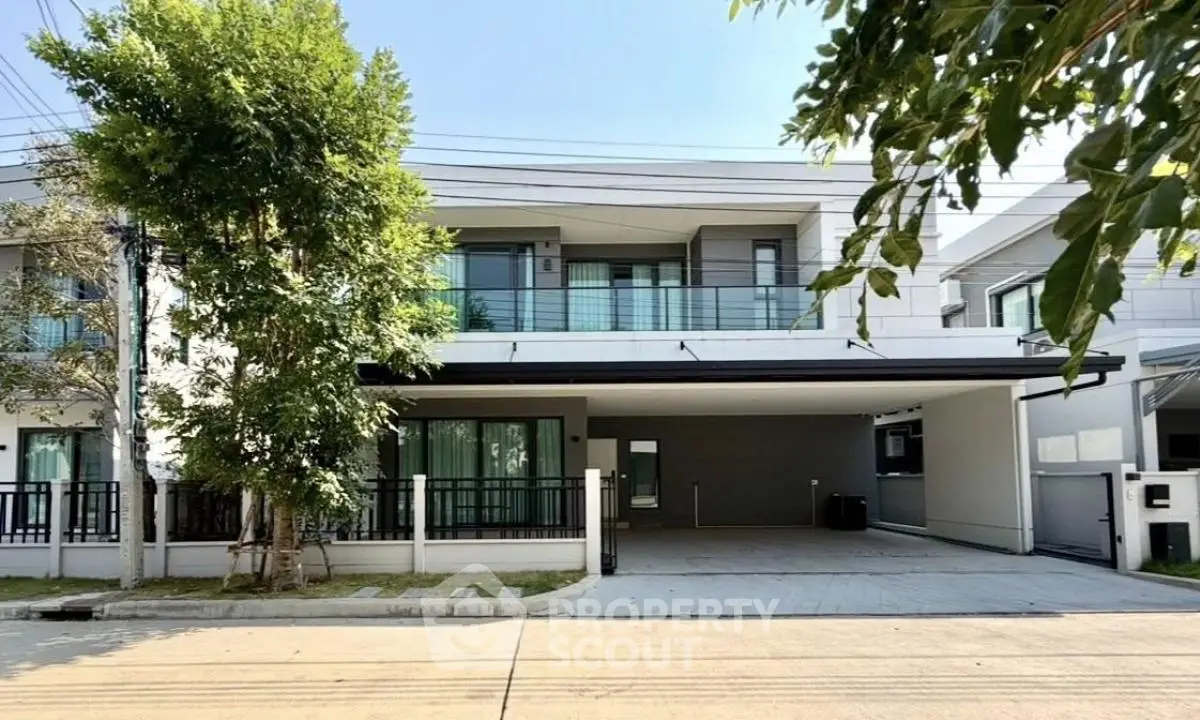 Modern two-story house with spacious driveway and lush greenery