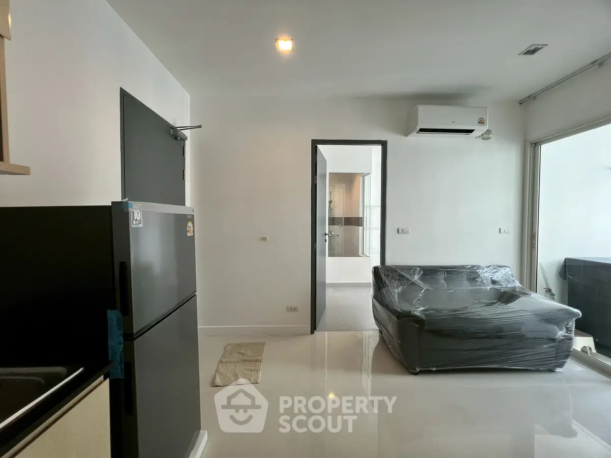 Modern living room with sleek black fridge and air conditioning