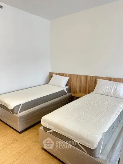 Modern twin bedroom with wooden flooring and minimalist design