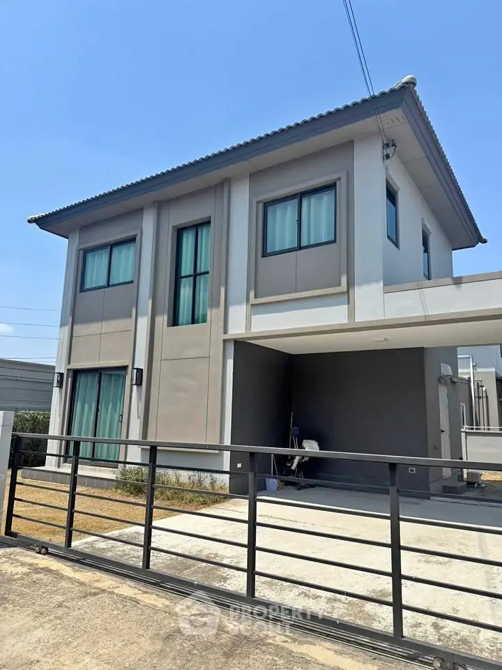 Modern two-story house with sleek design and spacious driveway, perfect for family living.