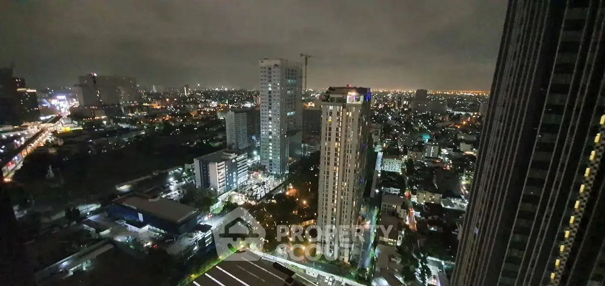 Stunning cityscape view from high-rise building at night with vibrant city lights.