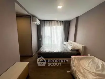 Modern bedroom with large window and stylish decor in a contemporary apartment.