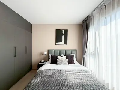 Modern bedroom with stylish decor and large window for natural light.