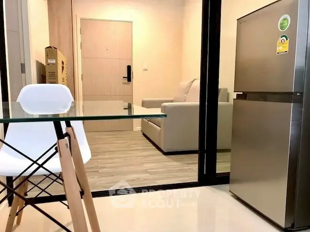Modern apartment interior with glass table and stainless steel fridge