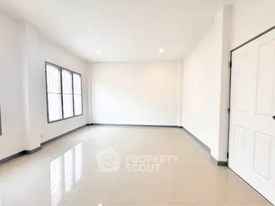 Spacious empty room with large windows and glossy tiled floor, perfect for customization.