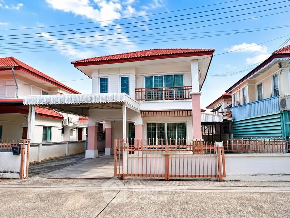 Charming two-story house with red roof and spacious driveway in a serene neighborhood.