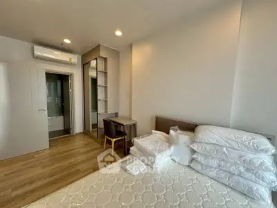 Modern bedroom with wooden flooring, built-in wardrobe, and air conditioning unit.