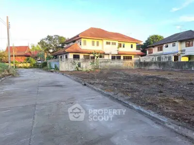 Spacious residential plot with adjacent houses, ideal for new construction in a serene neighborhood.
