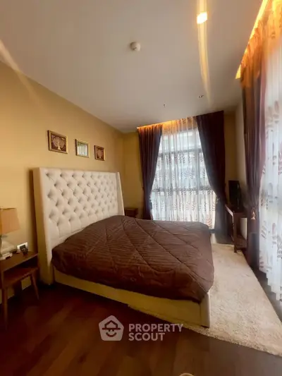 Luxurious bedroom with elegant decor and large windows offering natural light.