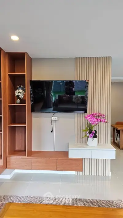 Modern living room with wall-mounted TV and stylish wooden shelving
