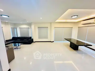 Spacious modern living room with sleek design and ample natural light, perfect for entertaining.
