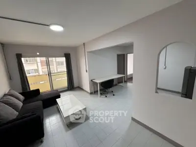 Spacious living room with modern furniture and large window for natural light.