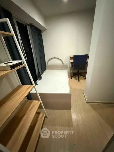 Cozy bedroom with modern furnishings and study area, perfect for urban living.