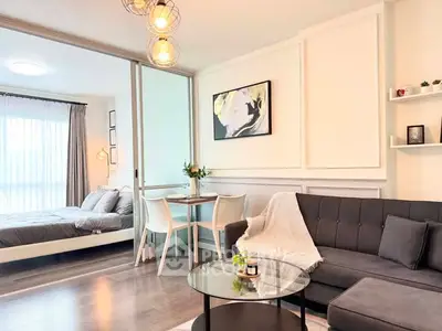 Modern open-plan living room with stylish decor and cozy bedroom view.