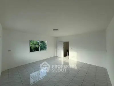 Spacious empty room with large window and tiled floor, perfect for customization.