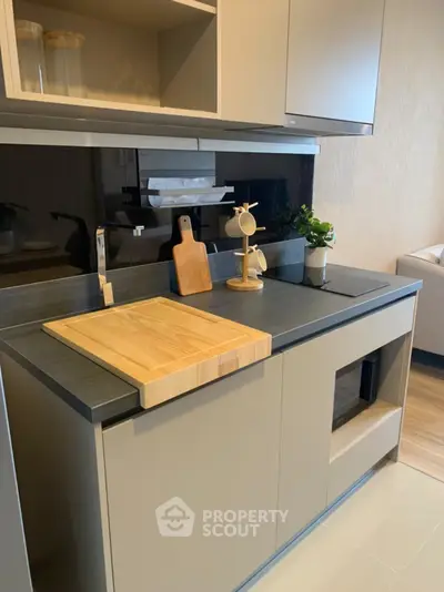 Modern kitchen with sleek cabinetry and stylish countertop in a contemporary apartment.