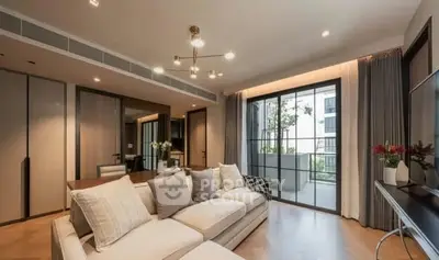 Spacious modern living room with elegant decor and large windows opening to a balcony.