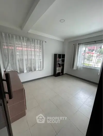 Bright and airy room with tiled flooring and large windows, perfect for versatile use.