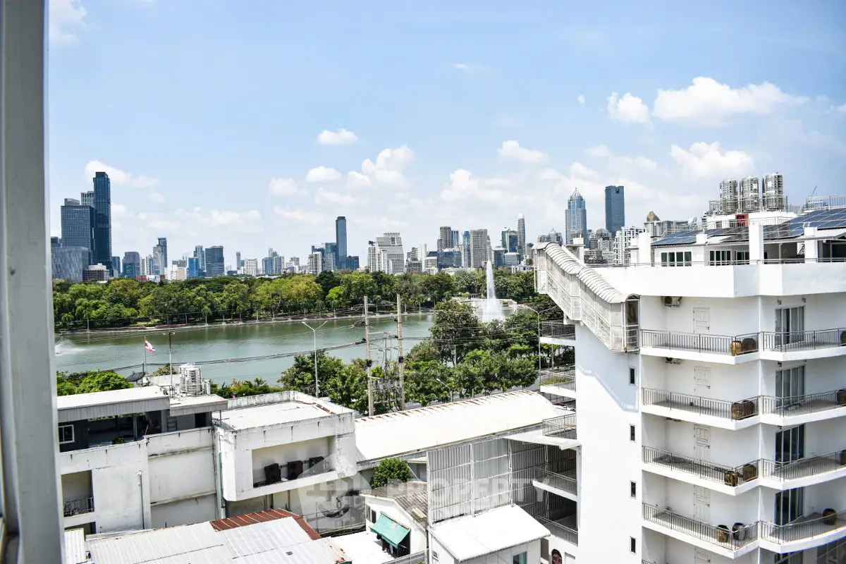Stunning cityscape view from high-rise building overlooking a serene river and lush greenery.