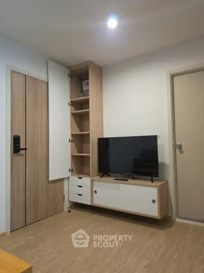 Modern living room with sleek wooden furniture and mounted TV, perfect for cozy urban living.