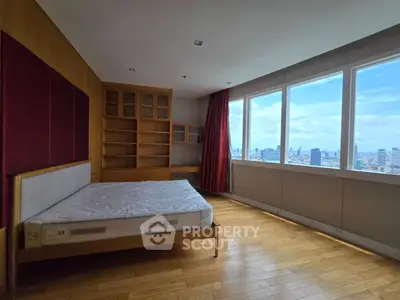 Spacious bedroom with city view and wooden flooring in modern apartment