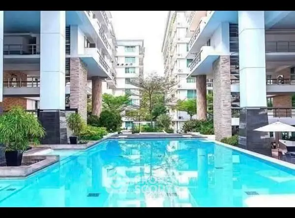 Luxurious apartment complex with stunning pool and modern architecture.