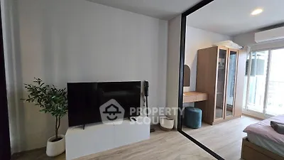 Modern living room with sleek TV setup and stylish decor in a contemporary apartment.