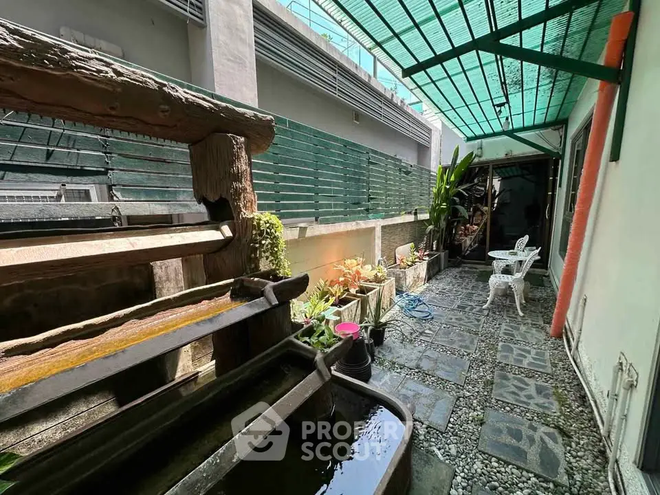 Charming garden patio with rustic water feature and seating area