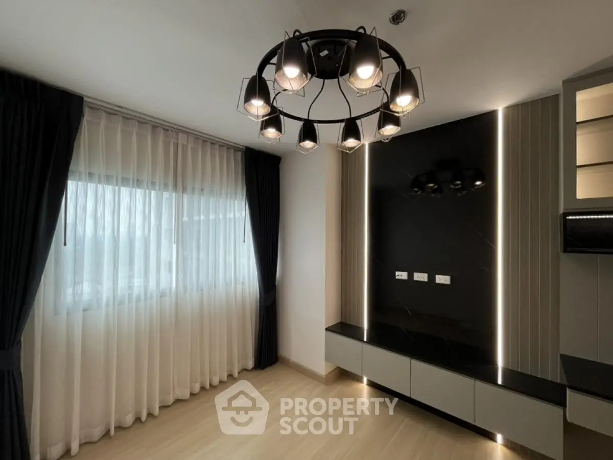 Modern living room with stylish chandelier and sleek entertainment wall unit