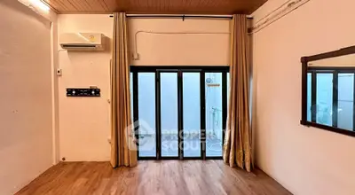 Spacious room with sliding glass doors and wooden flooring