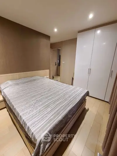 Modern bedroom with sleek design and ample storage in a stylish apartment.