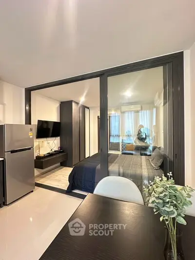 Modern apartment interior with open layout, featuring a sleek kitchen and cozy living area.