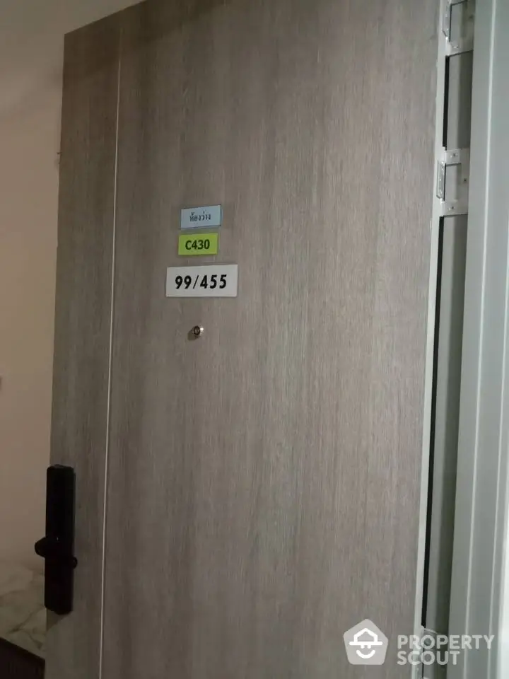 Modern apartment door with secure lock and room number displayed