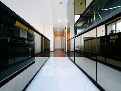 Sleek modern kitchen with glossy cabinets and marble flooring in luxury apartment