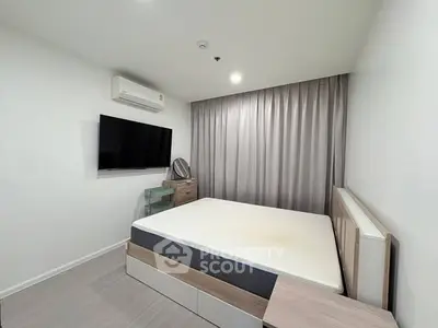 Modern bedroom with minimalist design, featuring a wall-mounted TV and sleek furniture.