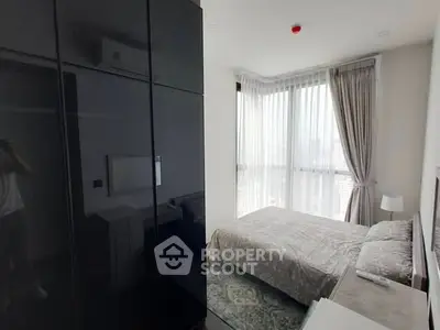Modern bedroom with large windows and elegant decor in a high-rise apartment.