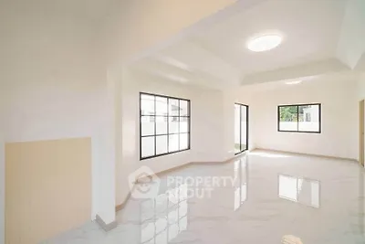 Spacious modern living room with large windows and glossy floors