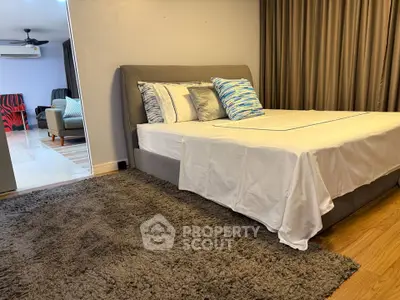 Spacious bedroom with modern decor and cozy rug in a stylish apartment.